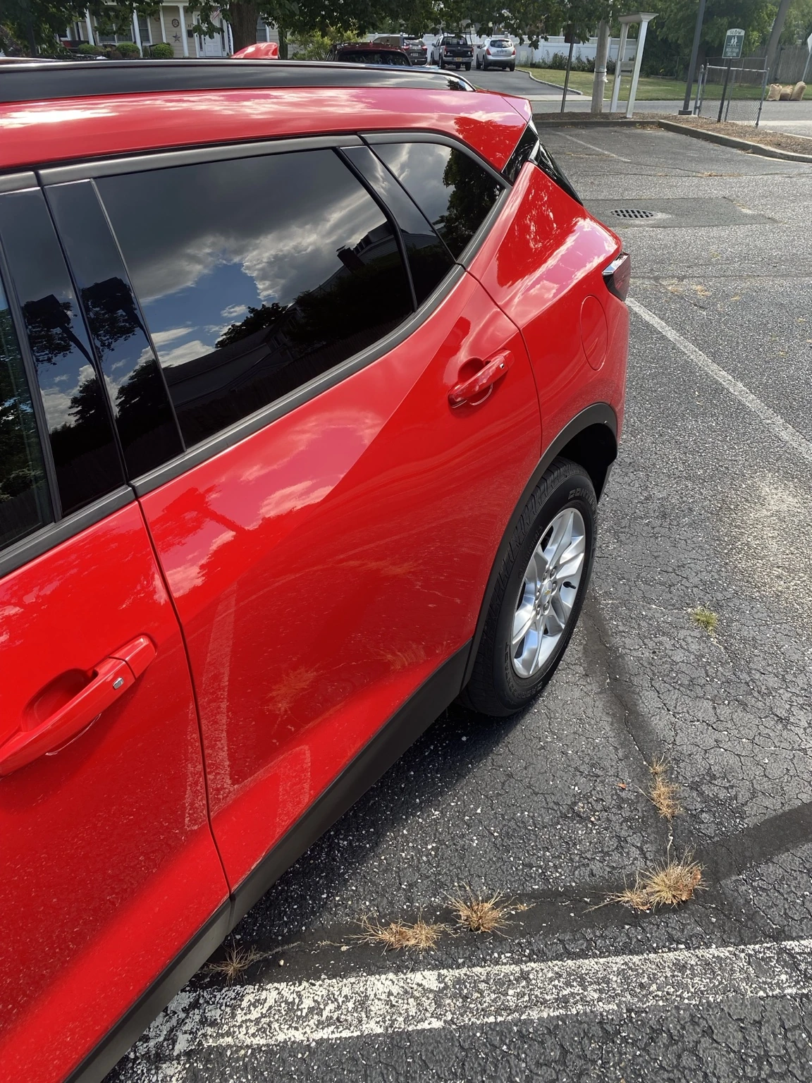 Glossy red car paint reflecting the sky after detailing